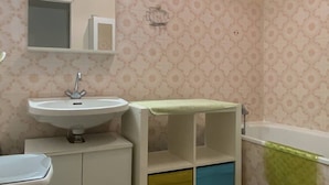 Ein Badezimmer mit Waschbecken, Spiegel und Badewanne.
