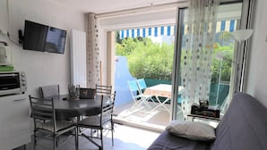 Un espacio habitable compacto con kitchenette, comedor y sofá.