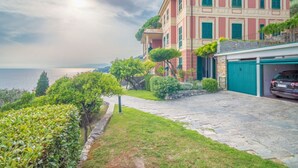 Ein Küsteneigentum mit gepflasterter Auffahrt, einer Garage und Blick auf das Meer.