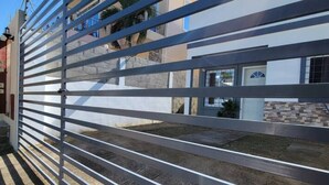 Un bâtiment moderne doté d’une grille en métal et d’une pelouse bien entretenue.
