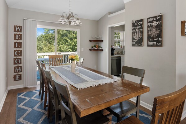Un comedor con una mesa de madera, sillas y vistas al exterior.
