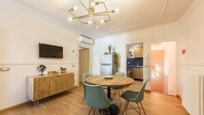 Eine moderne Küche mit Einbauofen, Kühlschrank und Essbereich mit rundem Tisch und Stühlen.
