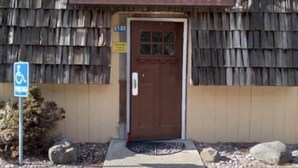 A restaurant named "The Wood Shed" with a rustic wooden exterior and a brown door.