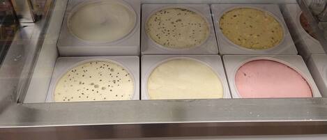 A food display case with six compartments containing different types of ice cream.