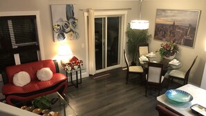 En moderne stue med en rød sofa, et glasbord og et spiseområde med et bord og stole af glas.