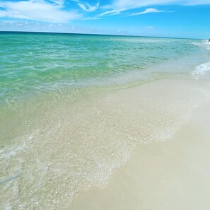 Una playa con agua turquesa cristalina y una orilla arenosa.