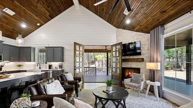 A spacious living area with a fireplace, comfortable seating, and a view of the outdoors. - Platinum Ridge - Luxury One Bedroom with Bunk Nook (Broken Bow)