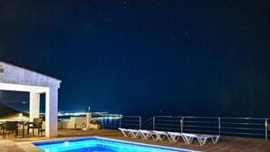 A rooftop pool with a view of the city at night. - Luxury villa with heated pool and sea views. (Salobreña)