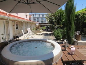 A hot tub surrounded by outdoor furniture, a wooden deck, and potted plants. - Ruby Charm Houses 10 D 120503/AL (Porto)