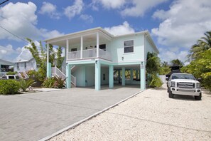A two-story house with a covered porch and a driveway.