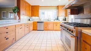 Una cocina moderna con armarios de madera, estufa de acero inoxidable y lavavajillas.