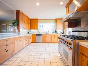 Een moderne keuken met houten kastjes, een roestvrijstalen fornuis en een vaatwasser.