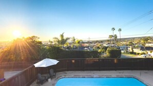 Una piscina con vistas a una zona residencial y palmeras.