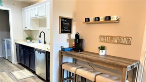 Een moderne keuken met een bar, een koffieapparaat en een bordje met een rookverbod.
