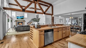 A spacious kitchen with wooden beams, a central island, and a dishwasher. - Lakefront Oasis near Lewiston & Niagara Falls (Wilson)