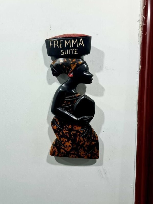 A black and orange abstract sculpture with the text "FREMA SUITE" on top.