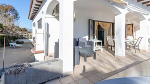 A covered outdoor patio area with a seating arrangement and a view of the surrounding landscape. - Erbanozi by Interhome (Empuriabrava)