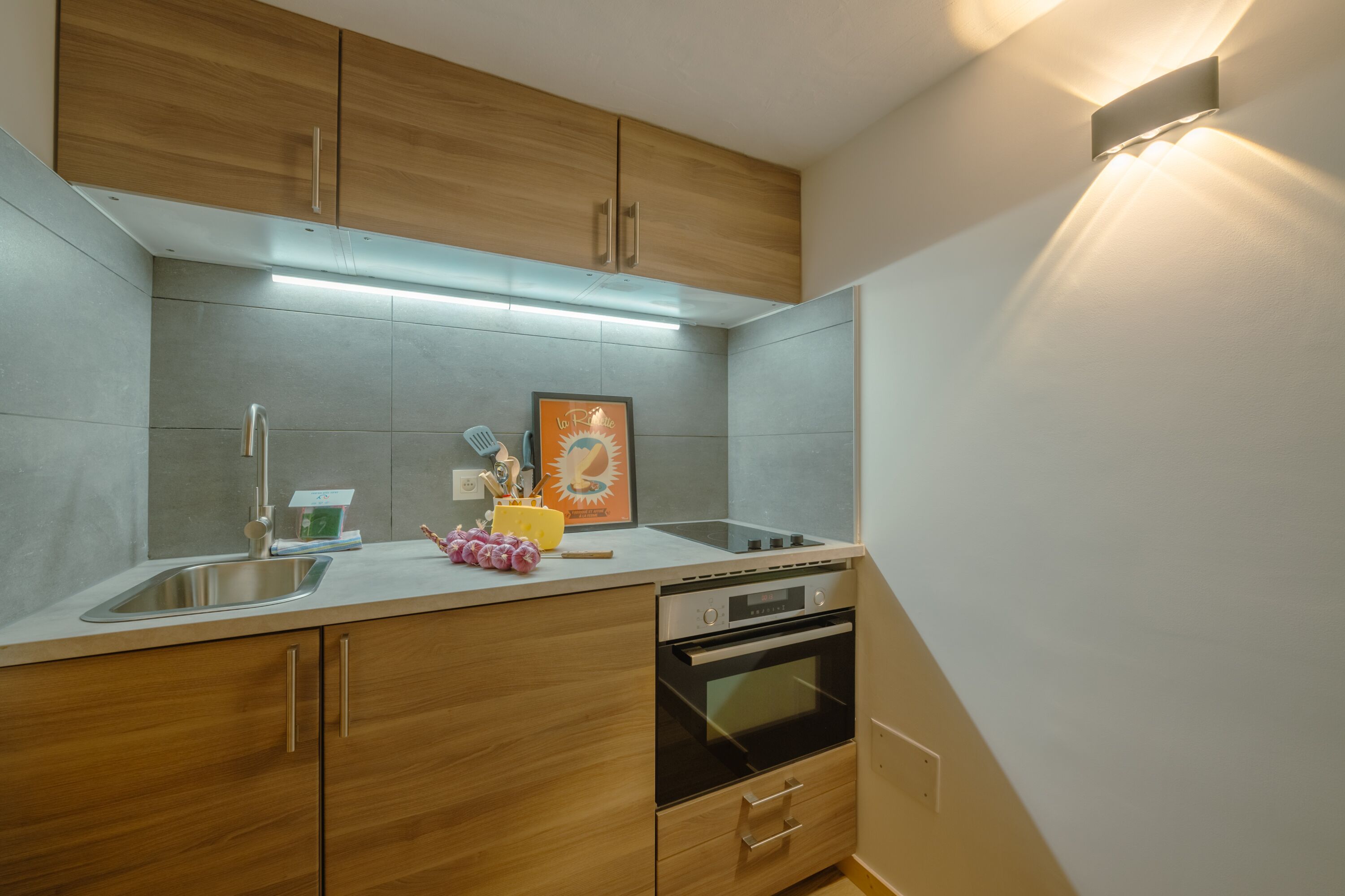 Een moderne keuken met houten kastjes, een roestvrijstalen spoelbak en een oven.