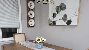 Ein Essbereich mit einem Holztisch, Bänken und einer Vase mit Sonnenblumen.
