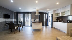A modern kitchen with a central island, built-in appliances, and a dining area with a table and chairs.