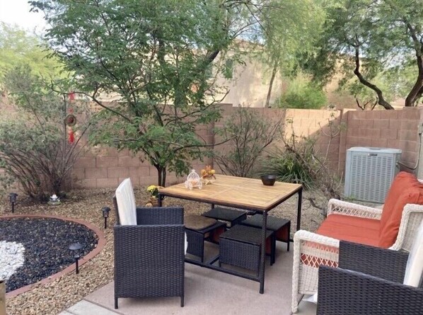 Relax in a serene outdoor setting surrounded by lush plants and a soothing water feature.