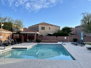 Relax by the rectangular pool surrounded by a tiled deck and lounge chairs.