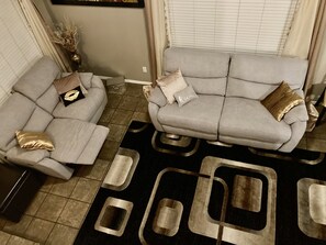 Relax in this stylish living room with two sofas, a geometric-patterned rug, and a decorative vase.