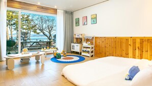 A hotel room with a large bed, a kitchenette, a dining area, and a view of the outdoors. - Yeosu Hi Mom Kids Family Pension Black (Yeosu)