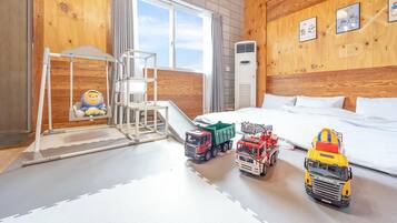 Ein Hotelzimmer mit Bett, Spielbereich inklusive Rutsche und Spielzeug-Lkw.