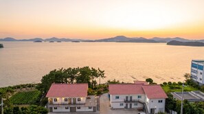Um imóvel costeiro com vista para o mar e montanhas ao longe.