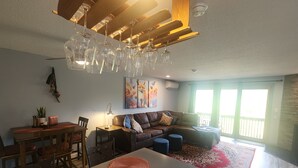 Ein modernes Wohnzimmer mit Essbereich, einer Couch und einem Deckenventilator.