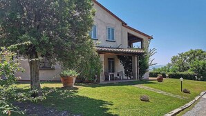 A two-story house with a covered patio and a well-maintained lawn. - Casa Raissa D: A characteristic and welcoming apartment that is part of a villa immersed in a splendid landscape, in a lovely little hamlet, with Free WI-FI. (Montaione)