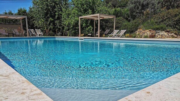 A rectangular swimming pool with clear blue water, surrounded by a tiled deck. - Casa Raissa D: A characteristic and welcoming apartment that is part of a villa immersed in a splendid landscape, in a lovely little hamlet, with Free WI-FI. (Montaione)