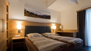 A double bed with headboards, bedside tables, and wall-mounted lamps.