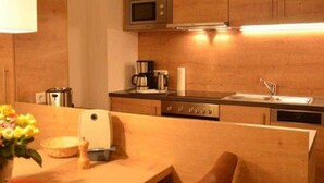 Une cuisine compacte avec des meubles en bois, un four à micro-ondes, une machine à café et un évier.