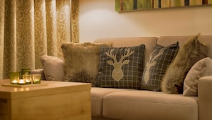 A living room with a sofa, decorative pillows, a lamp, and a painting on the wall. - GRA-006 Gipfelglück vacation apartment with whirlpool & terrace - Grafenmatt Residence (Feldberg (Schwarzwald))
