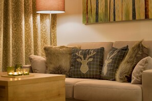 A living room with a sofa, decorative pillows, a lamp, and a painting on the wall. - GRA-006 Gipfelglück vacation apartment with whirlpool & terrace - Grafenmatt Residence (Feldberg (Schwarzwald))