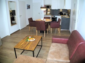 Un espacio habitable compacto con comedor, kitchenette y zona de estar.
