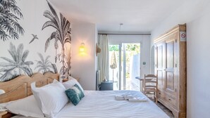 A hotel room with a bed, a nightstand, a wardrobe, and a view of the outdoors. - Villa Paradis (Roquebrune-sur-Argens)