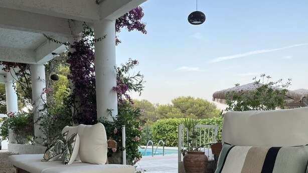 A covered outdoor seating area with two sofas and a table, surrounded by greenery and a pool in the background. - Villa Paradis (Roquebrune-sur-Argens)