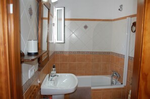 A bathroom with a sink, mirror, and bathtub. - 'El Rinconcito de Rosa' Apartment with Wi-Fi & AC, Perfect for Couples (Nerja)