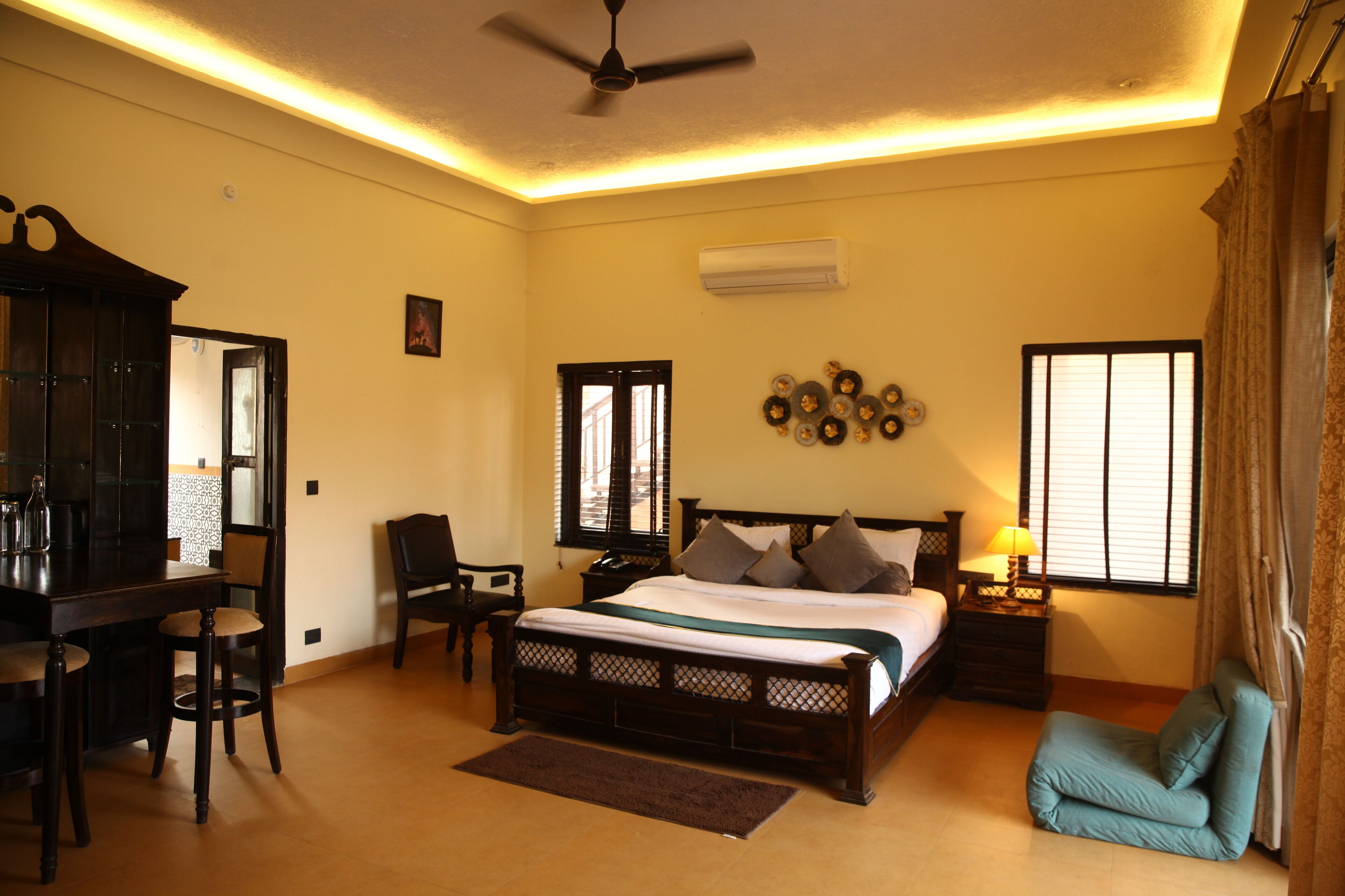 A bedroom with a bed, a desk, a chair, a nightstand, and a ceiling fan.