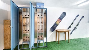 A room with a blue cabinet, a wooden table, and skis mounted on the wall.