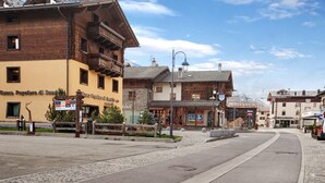 A street with buildings, including a yellow building with a sign 'Banca Popolare di Sondrio.'