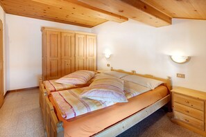 A bedroom with a wooden bed, a wardrobe, and a nightstand.