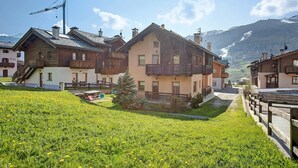 Ein Wohngebäude mit Balkon, Treppe und Blick auf einen Berg.
