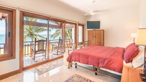 Une chambre avec un lit, une télévision et vue sur la plage.