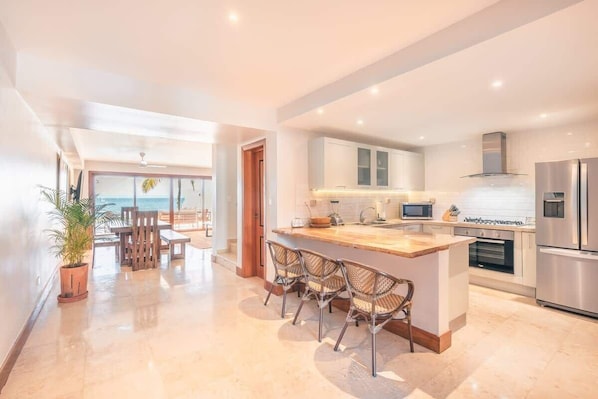 A modern kitchen with a central island, stainless steel appliances, and a view to the outside. - Ocean view villa with private pool in Samana (Samaná)