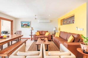 A living room with a wooden dining table, two sofas, and a coffee table. - Ocean view villa with private pool in Samana (Samaná)