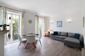 Un coin repas avec une table et des chaises en verre, un canapé et une lampe.